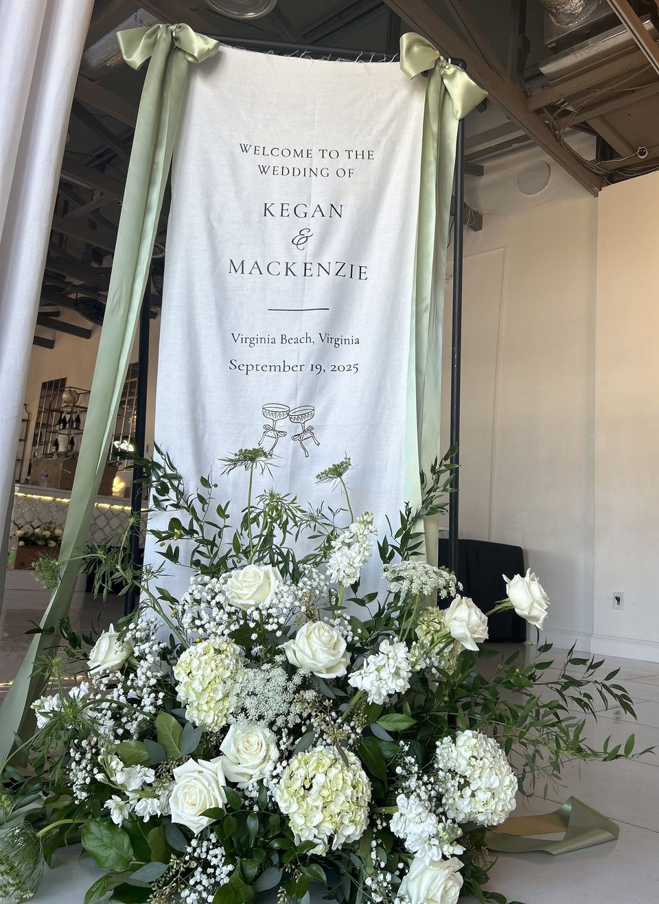 Welcome banner for Kegan and Mackenzie with white roses and greenery