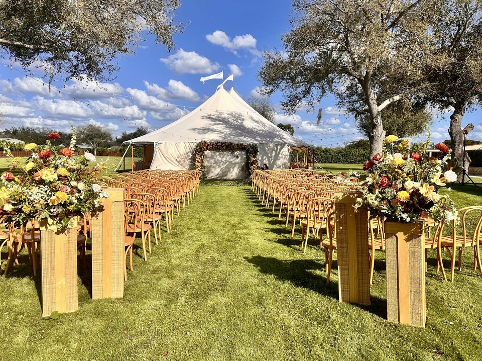Sailcloth tent ceremony with autumn pillar arrangements lining the aisle