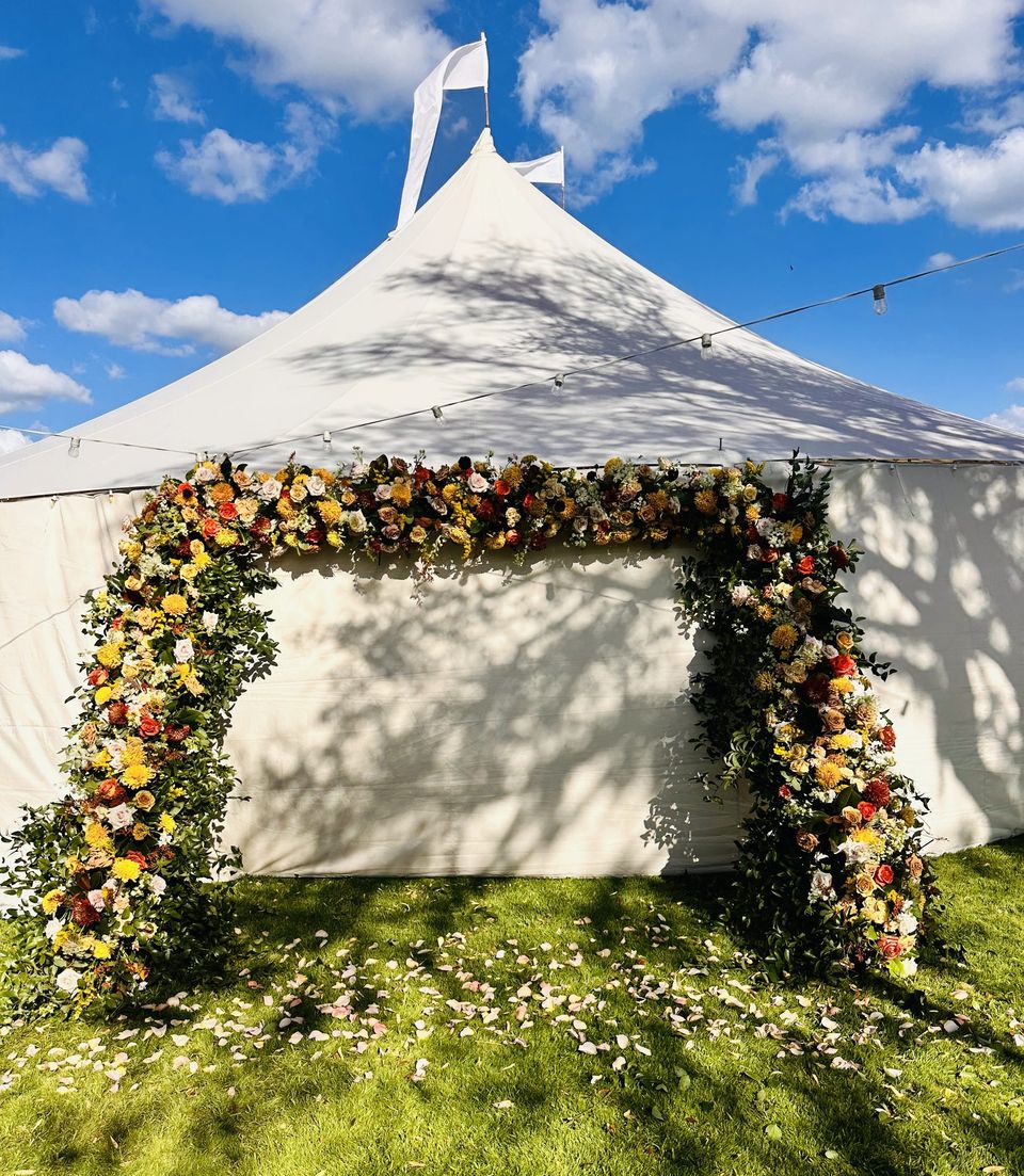 Sailcloth tent entrance covered in autumn florals