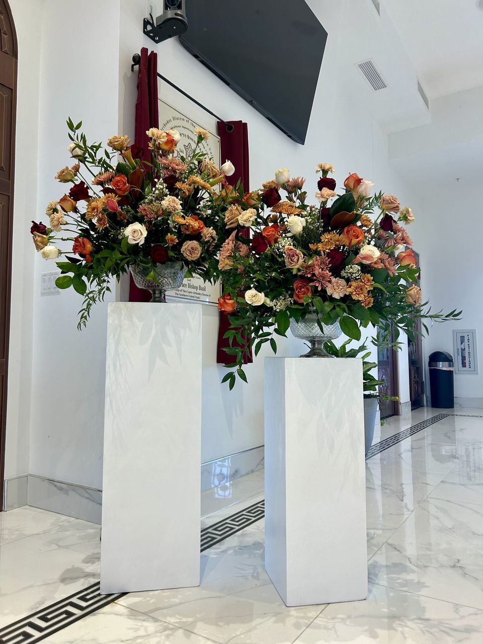 Two pedestal arrangements in a church entry, autumn palette